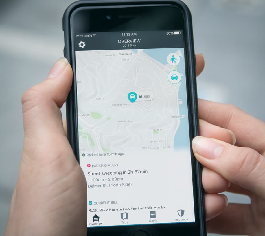 Person holding smartphone and looking at Metromile app