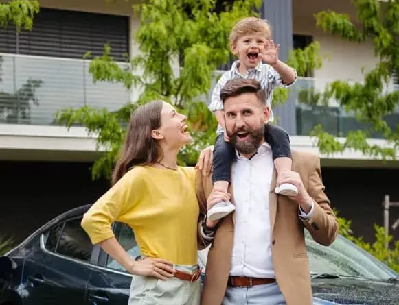 Family of three in front of a car