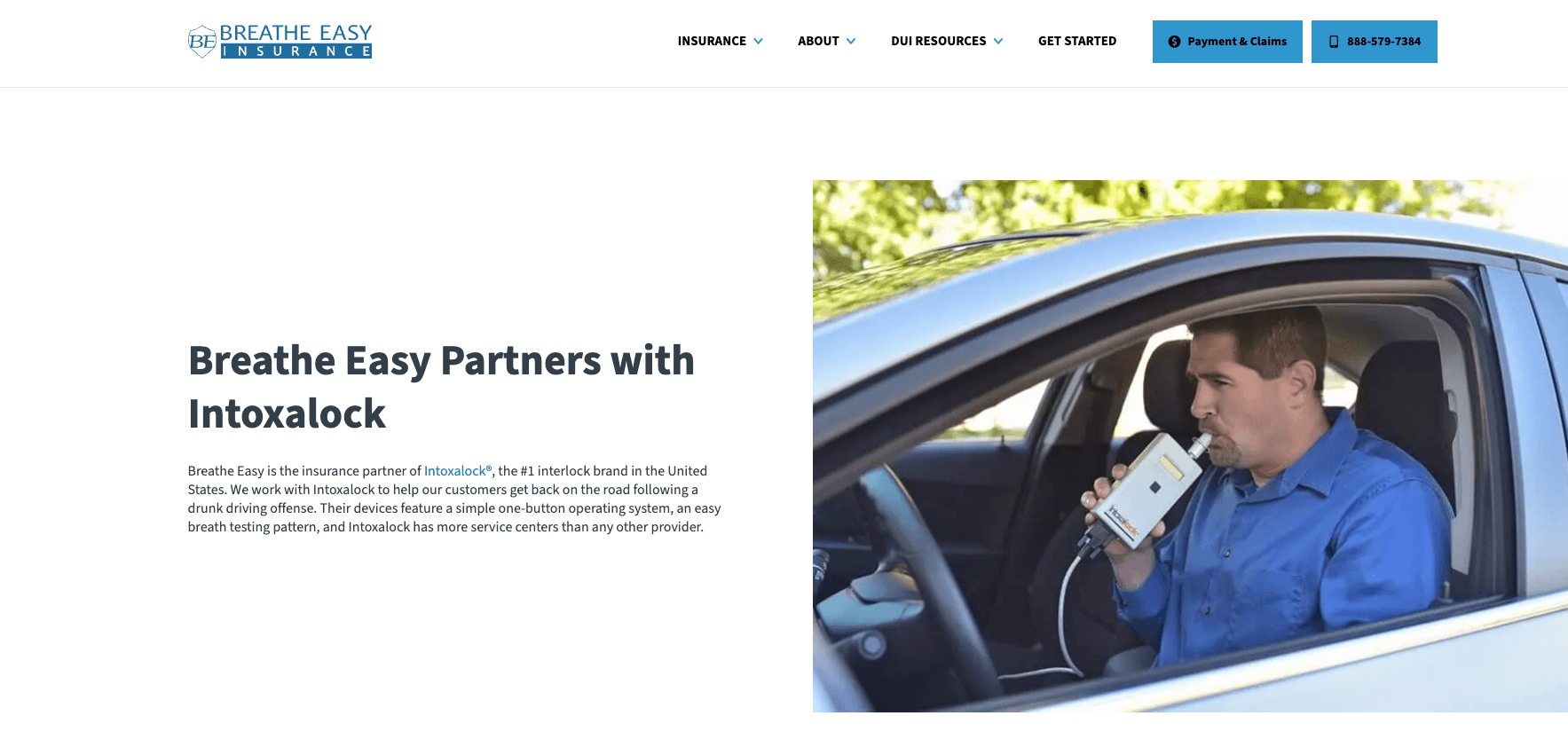 Breathe Easy/Intoxalock partnership. Man behind steering wheel breathing into DUI interlock device.