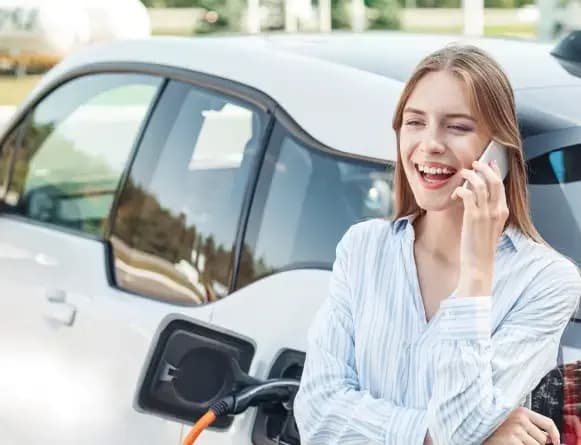 Woman on phone charging car